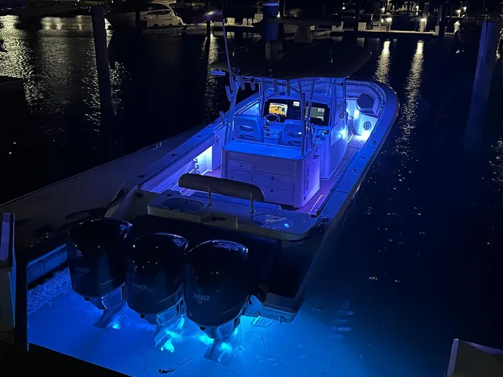  Yacht Photos Pics 2018 Cobia 344 Center Console boat illuminated with blue lights at night.
