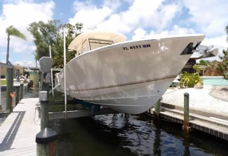  Yacht Photos Pics 2018 Cobia 344 Center Console boat docked on a lift under a sunny sky.