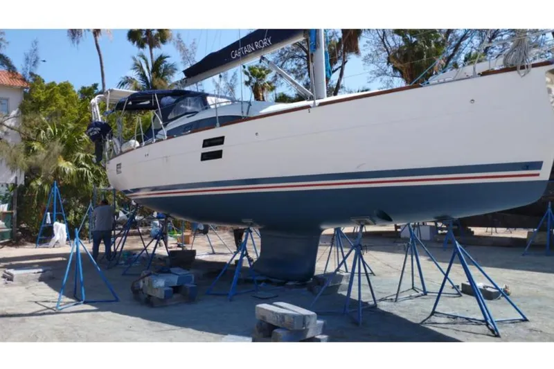  Yacht Photos Pics 2018 Elan Impression 40 sailboat on stands, undergoing maintenance in a sunny yard.