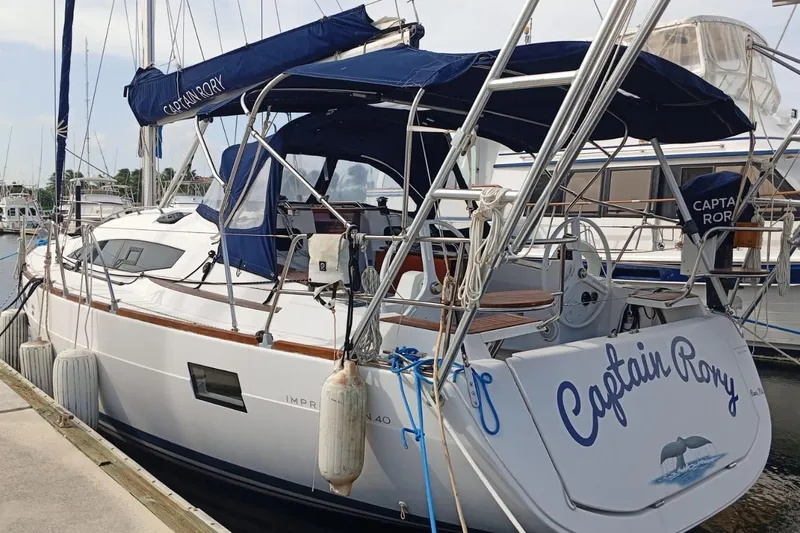  Yacht Photos Pics 2018 Elan Impression 40 sailboat "Captain Rory" docked at marina, featuring blue canopy.