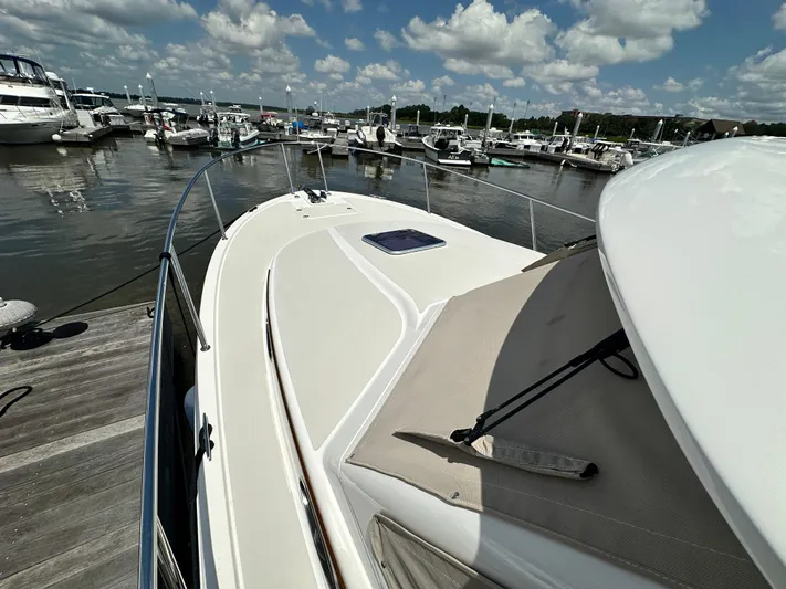  Yacht Photos Pics 2022 Back Cove 34O yacht docked at marina under a partly cloudy sky.