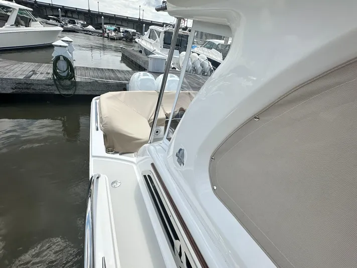 Yacht Photos Pics 2022 Back Cove 34O docked at marina, showcasing sleek design and covered seating area.
