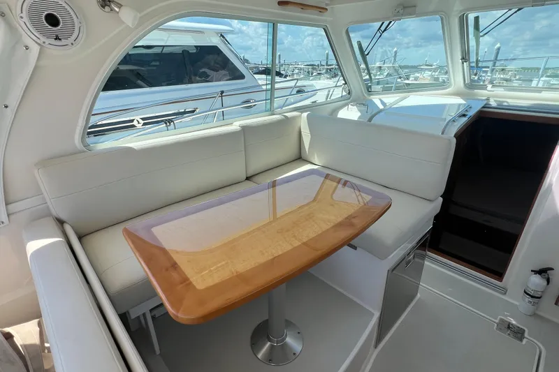  Yacht Photos Pics Interior of 2022 Back Cove 34O yacht with white seating and wooden table.