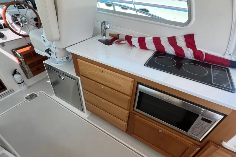  Yacht Photos Pics 2022 Back Cove 34O yacht interior with kitchenette, featuring stove, microwave, and sink.