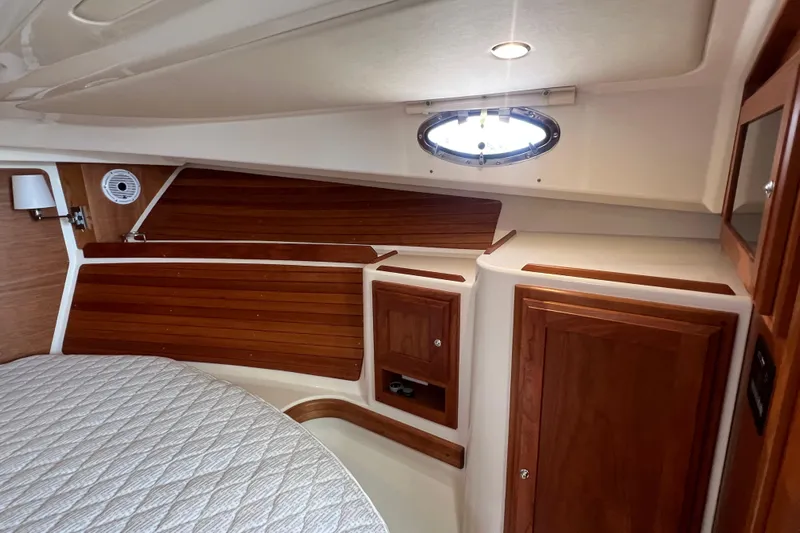  Yacht Photos Pics 2022 Back Cove 34O cabin interior with wood paneling and porthole window.