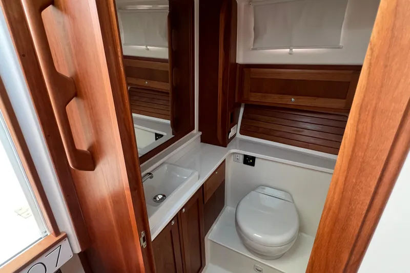  Yacht Photos Pics Luxurious bathroom in 2022 Back Cove 34O yacht with wooden cabinetry and modern fixtures.
