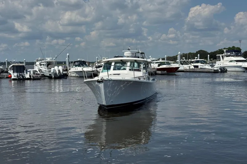  Yacht Photos Pics 2022 Back Cove 34O boat cruising in a marina under a cloudy sky.