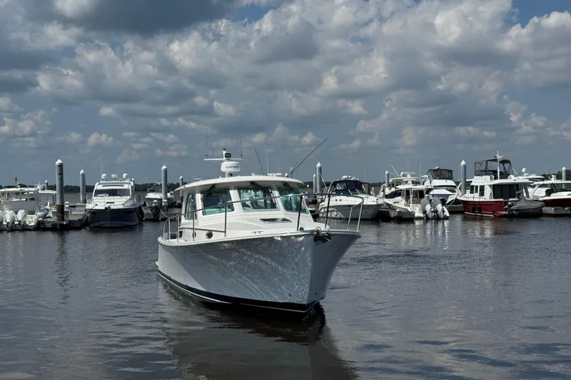  Yacht Photos Pics 2022 Back Cove 34O boat docked in a marina under a cloudy sky.