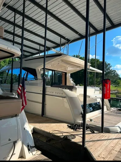  Yacht Photos Pics 2023 Prestige 520S yacht docked under a covered marina with clear skies.