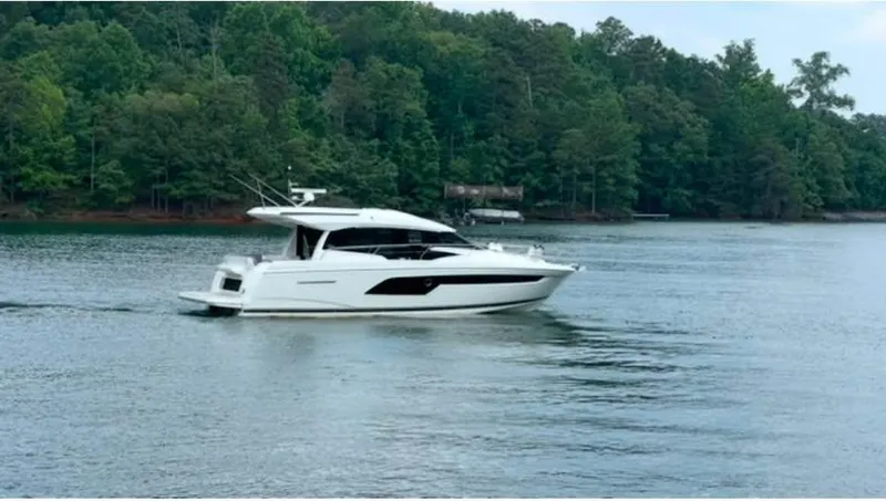  Yacht Photos Pics 2023 Prestige 520S yacht cruising on a serene lake with lush forest backdrop.