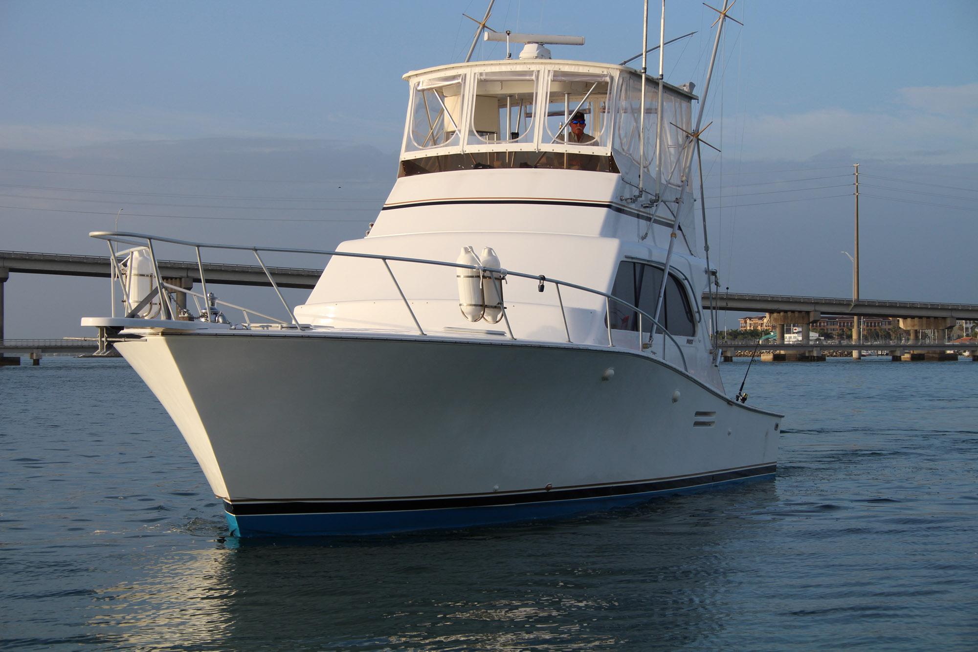 1990 Post 44 Sport Fisherman boat on calm water, bridge in background.