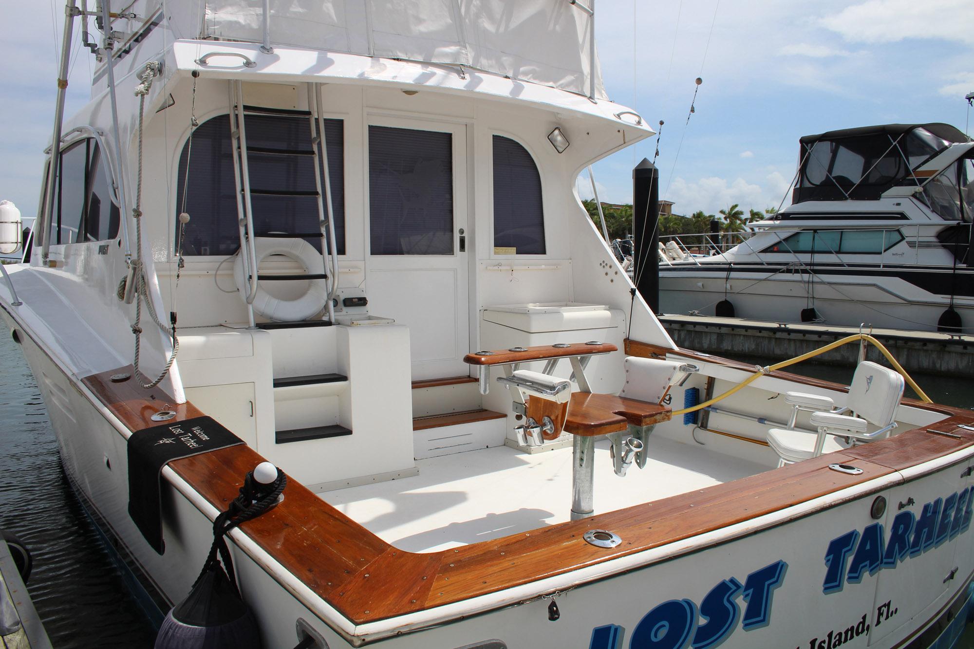 1990 Post 44 Sport Fisherman yacht docked, featuring spacious deck and fishing chair.