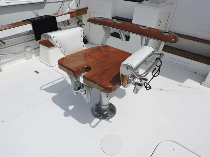  Yacht Photos Pics Fishing chair on 1990 Post 44 Sport Fisherman boat deck, featuring rod holders and wooden seat.