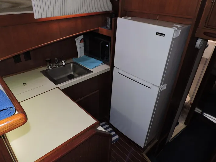 Yacht Photos Pics 1990 Post 44 Sport Fisherman kitchen with sink, refrigerator, and microwave.