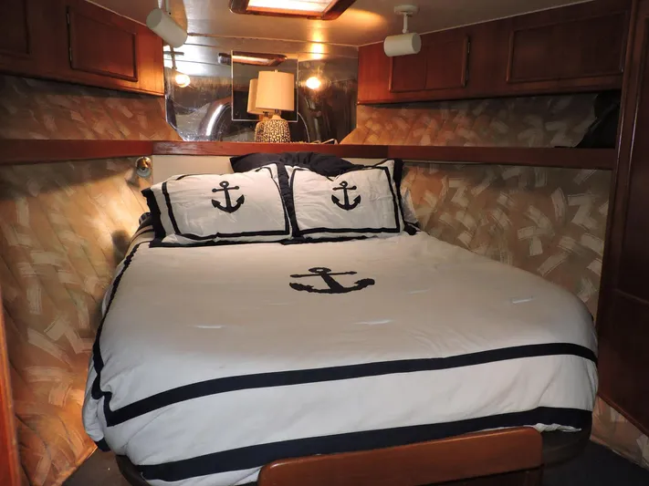  Yacht Photos Pics Cozy cabin bedroom in 1990 Post 44 Sport Fisherman boat with nautical-themed bedding.
