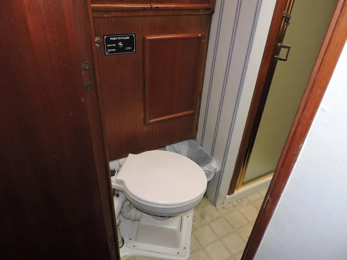  Yacht Photos Pics 1990 Post 44 Sport Fisherman boat bathroom with wooden paneling and compact toilet.