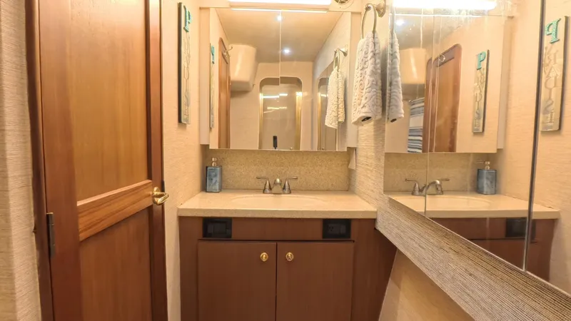 No Name Yacht Photos Pics Luxurious bathroom interior of 2002 Ocean Yachts 52 SUPER SPORT with wooden cabinetry and mirrored walls.