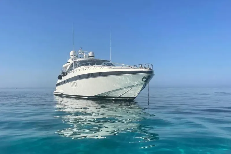  Yacht Photos Pics Luxury 2006 Mangusta 80 yacht anchored on calm, clear blue sea under a bright sky.