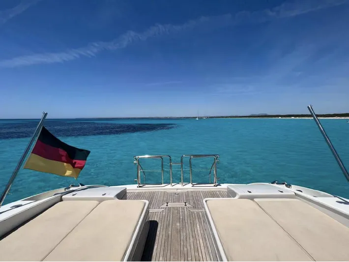  Yacht Photos Pics Mangusta 80 yacht deck overlooking clear blue sea, 2006 model, with a flag waving.