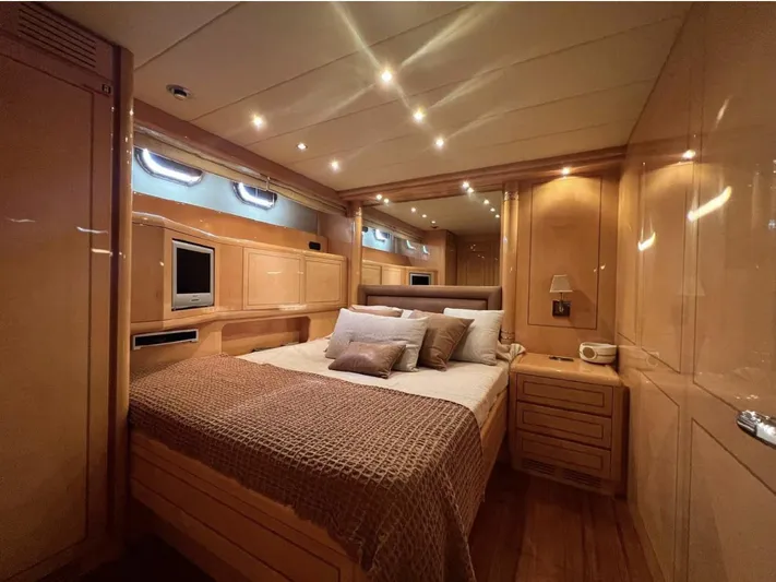  Yacht Photos Pics Luxurious 2006 Mangusta 80 yacht bedroom with elegant wood paneling and ambient lighting.