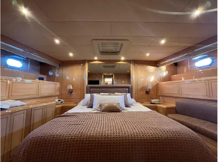  Yacht Photos Pics Luxurious bedroom interior of 2006 Mangusta 80 yacht with elegant wood paneling and ambient lighting.