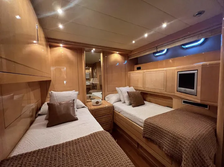  Yacht Photos Pics Luxurious 2006 Mangusta 80 yacht cabin with twin beds, wood paneling, and ambient lighting.