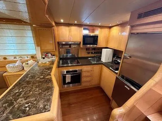  Yacht Photos Pics Luxurious kitchen interior of 2006 Mangusta 80 yacht with modern appliances and wooden cabinetry.