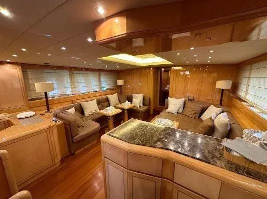  Yacht Photos Pics Luxurious interior of a 2006 Mangusta 80 yacht with elegant wood finishes and plush seating.
