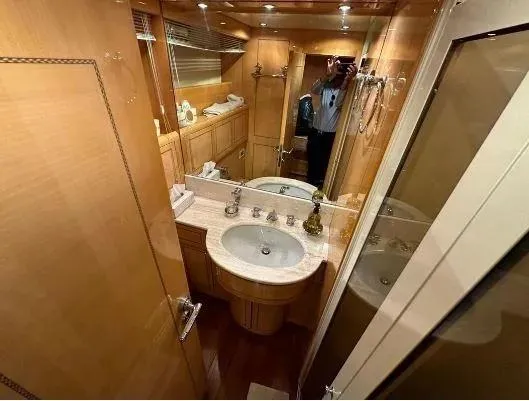  Yacht Photos Pics Luxurious bathroom interior of 2006 Mangusta 80 yacht with elegant wood finish.