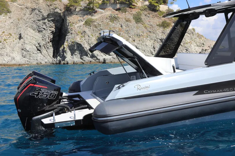  Yacht Photos Pics 2025 Ranieri CAYMAN 45.0 Cruiser in clear blue water near rocky coastline.