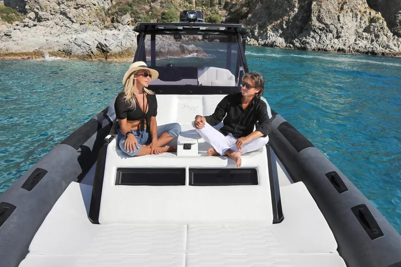  Yacht Photos Pics Two people relaxing on a 2025 Ranieri CAYMAN 45.0 Cruiser in clear blue waters.