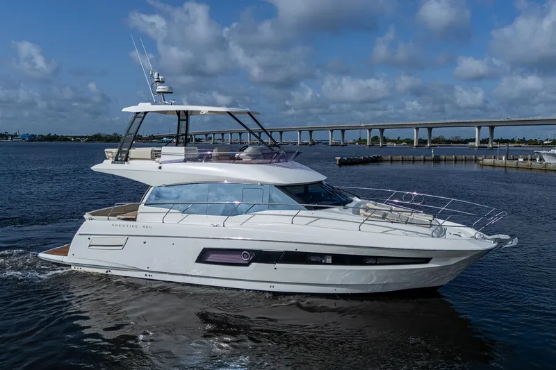Pamper You Yacht Photos Pics 2019 Prestige 460 yacht cruising on a calm river under a cloudy sky.