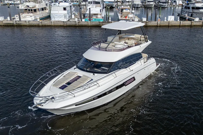 Pamper You Yacht Photos Pics 2019 Prestige 460 yacht cruising in a marina, surrounded by other boats.