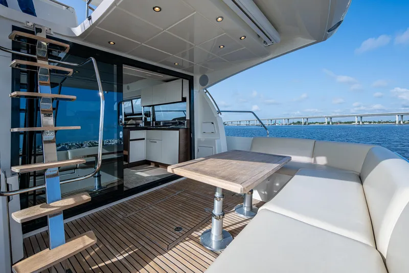 Pamper You Yacht Photos Pics Luxurious 2019 Prestige 460 yacht deck with seating, table, and ocean view.