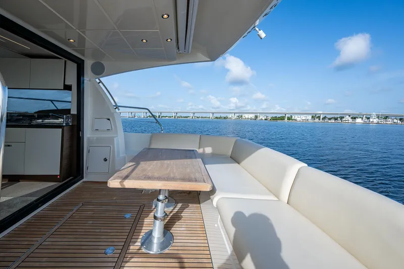 Pamper You Yacht Photos Pics Luxurious 2019 Prestige 460 yacht deck with seating, table, and scenic water view.