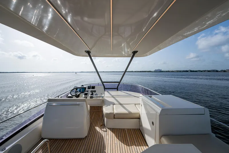 Pamper You Yacht Photos Pics Luxurious 2019 Prestige 460 yacht deck with seating, overlooking serene waters.