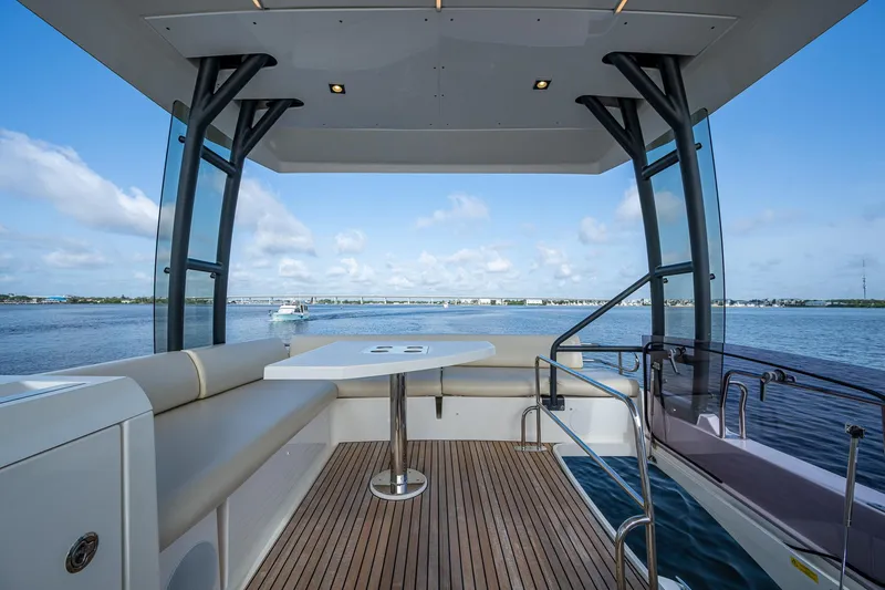 Pamper You Yacht Photos Pics Luxurious 2019 Prestige 460 yacht deck with seating, table, and scenic water view.