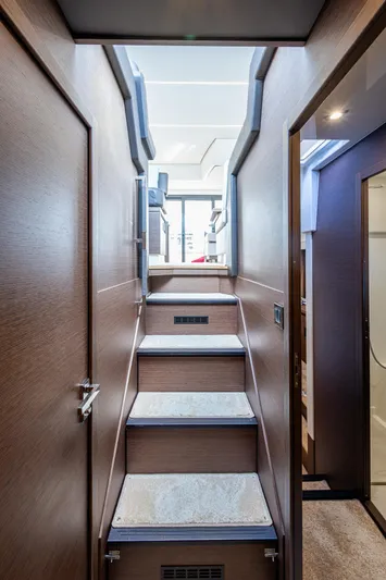 Pamper You Yacht Photos Pics Interior staircase of 2019 Prestige 460 yacht, featuring modern design and wood finish.