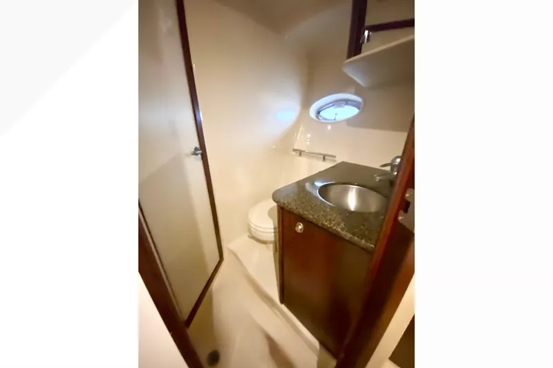  Yacht Photos Pics 2007 Sea Ray 38 Sundancer bathroom with sink, toilet, and porthole window.