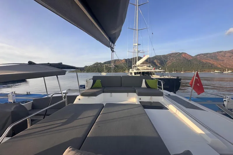  Yacht Photos Pics 2020 Fountaine Pajot Saona 47 catamaran with spacious deck, scenic mountain backdrop.