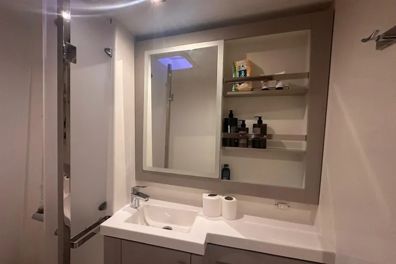  Yacht Photos Pics Modern bathroom on 2020 Fountaine Pajot Saona 47 yacht with sink, mirror, and toiletries.