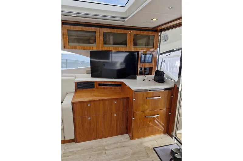 Mon Trésor Yacht Photos Pics Luxurious interior of 2020 Riviera 6000 Sport Yacht Platinum Edition with wood cabinetry and modern amenities.