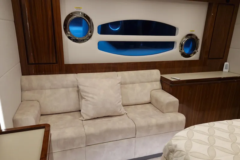Mon Trésor Yacht Photos Pics Luxurious interior of 2020 Riviera 6000 Sport Yacht Platinum Edition with plush seating and porthole windows.