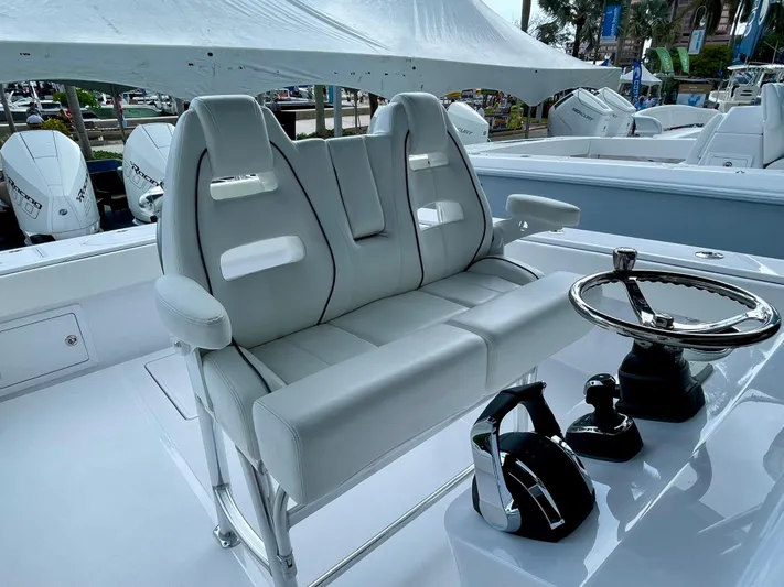 Reel Chaos Yacht Photos Pics Luxury seating and helm of 2022 Bahama 35 Open boat, featuring modern controls and design.