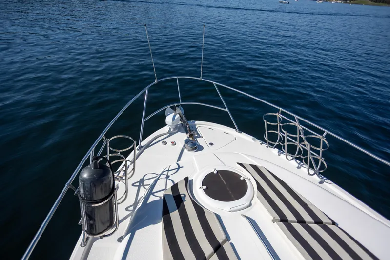 Seacougs Yacht Photos Pics 2008 Meridian 341 Sedan yacht bow on calm water, featuring striped cushions and metal railings.