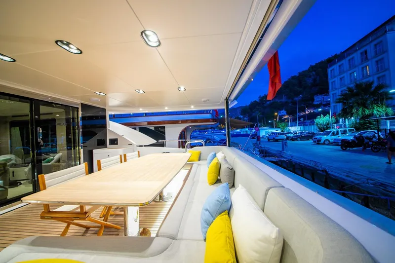 Nirvana By The Sea Yacht Photos Pics Luxurious 2019 Azimut Grande 27 METRI yacht deck with elegant seating and dining area at dusk.