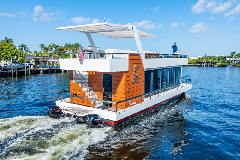  Yacht Photos Pics Modern 2023 Reina 44DR houseboat cruising on a sunny day with clear blue skies.