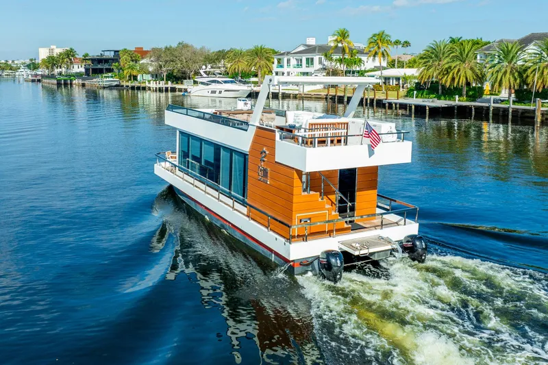 Yacht Photos Pics Modern 2023 Reina 44DR yacht cruising on a scenic waterway with palm trees.