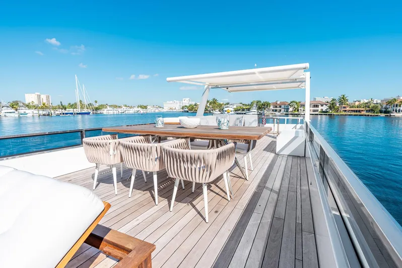  Yacht Photos Pics Luxurious Reina 44DR yacht deck with dining area, overlooking serene waterfront views, 2023 model.