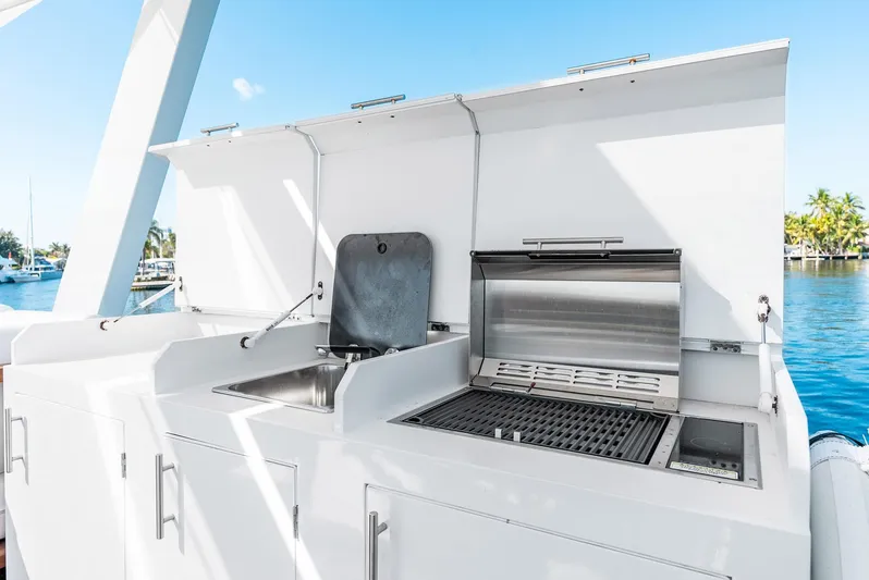 Yacht Photos Pics Outdoor kitchen on a 2023 Reina 44DR yacht with grill and sink, ocean view.